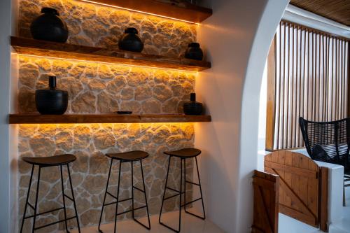 a bar with stools in front of a stone wall at Captain Zeppos in Pollonia