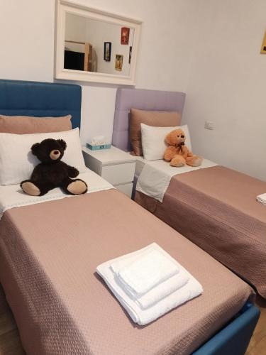 two teddy bears sitting on two beds in a room at Al Nido delle rondini 2 in Vaprio dʼAdda