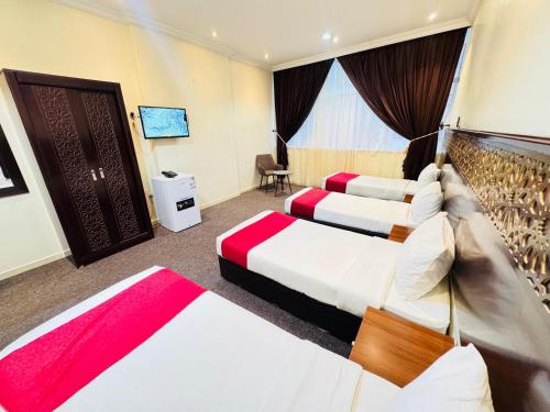 pokój hotelowy z 3 łóżkami i oknem w obiekcie Rafahya Hotel 2 w Mekce