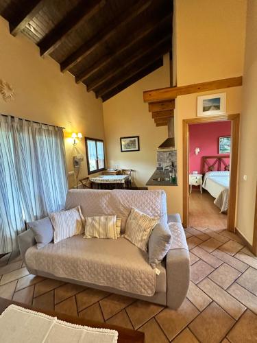 a living room with a couch and a bedroom at Apartamentos Rurales La Carbayala in Oviñana