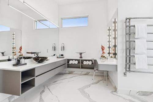 a bathroom with two sinks and a mirror at Luxury New Modern Beach Mansion in BEST Location! in Jupiter