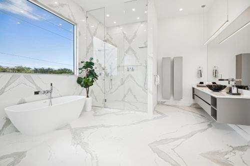a white bathroom with a tub and a sink at Luxury New Modern Beach Mansion in BEST Location! in Jupiter