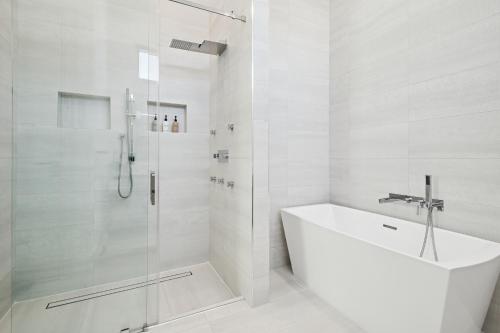 a white bathroom with a shower and a tub and a sink at Luxury New Modern Beach Mansion in BEST Location! in Jupiter
