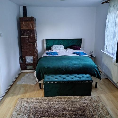 ein Schlafzimmer mit einem Bett mit einer grünen Bettdecke in der Unterkunft The vacation home in Bran