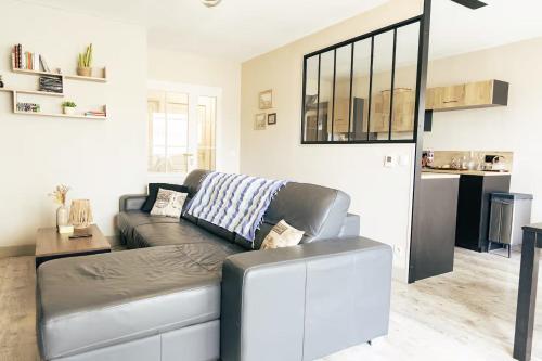 a living room with a couch and a table at Grand T2 lumineux, 74 m in Villefranche-sur-Saône