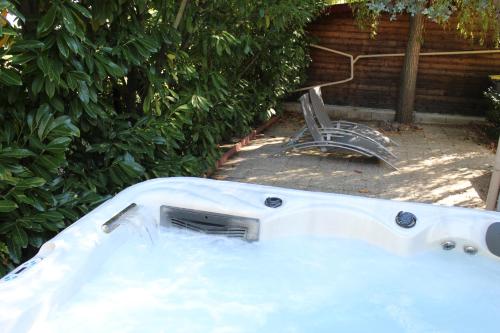 a white bath tub with a faucet in a yard at Ô Rethel Jacuzzi, Gîte Ardennes in Rethel