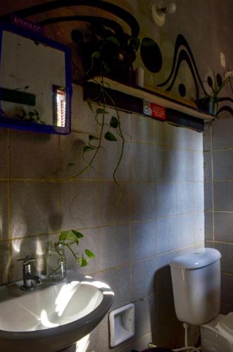 a bathroom with a sink and a toilet and a mirror at Quarto Privativo Casal - Banheiro Compartilhado in Pipa