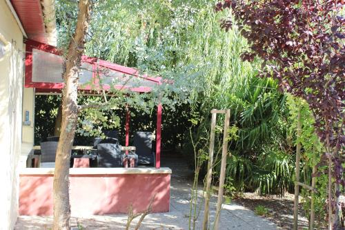 a garden with a red pergola and a patio at Ô Rethel Jacuzzi, Gîte Ardennes in Rethel