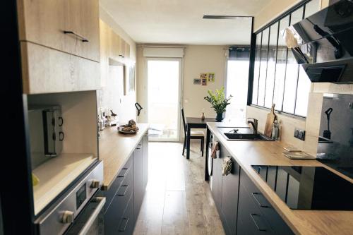 a kitchen with a sink and a counter top at Grand T2 lumineux, 74 m in Villefranche-sur-Saône
