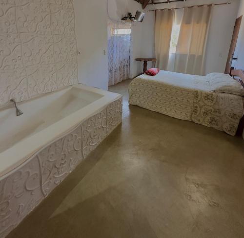 a bathroom with a bath tub and a bed at FamilySpace in Búzios