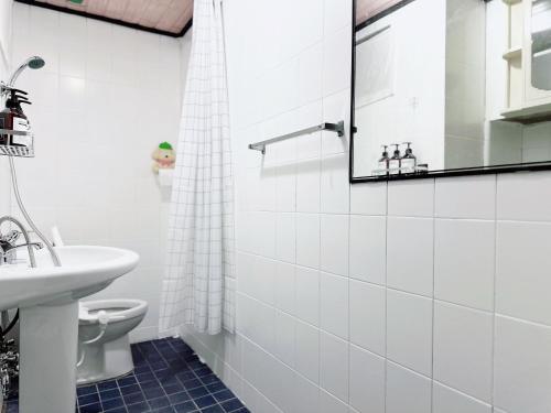 Un baño blanco con lavabo e inodoro. en Arang Stay Seoul 동대문, en Seúl