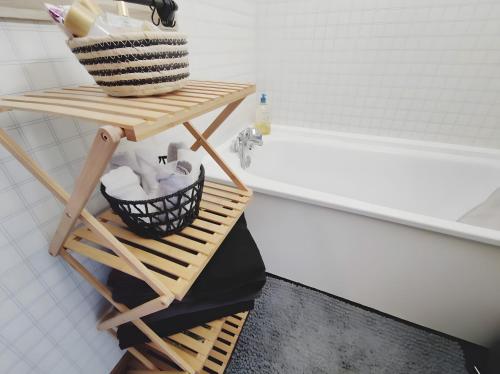 Un baño con una cesta en un estante junto a una bañera. en Studio au coeur de Praloup, en Pra-Loup