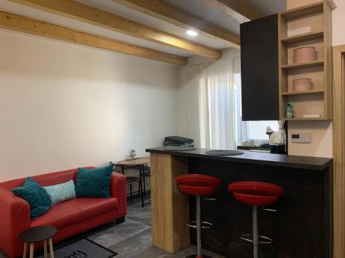 a living room with a red couch and a bar at Apartmán29 in Nové Mesto nad Váhom