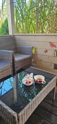 a table with two cups and bowls on a patio at Na Źródlanej in Wielgie