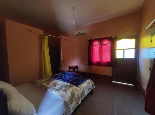 a bedroom with a bed and a window at Le LAC Auberge Camping Todra in Tinerhir