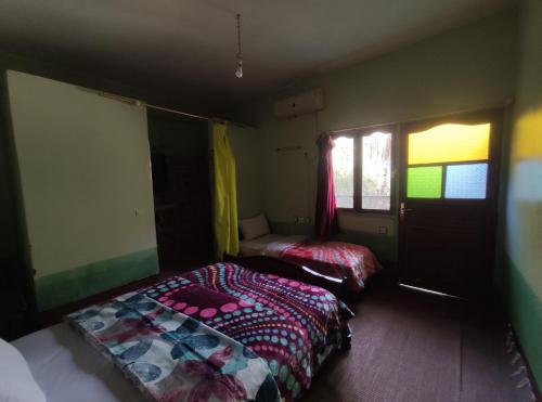 a bedroom with two beds and a window at Le LAC Auberge Camping Todra in Tinerhir