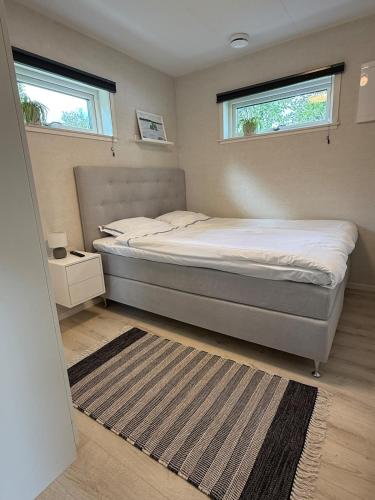 a bedroom with a bed and two windows at Villa Guldkusten in Kolsva