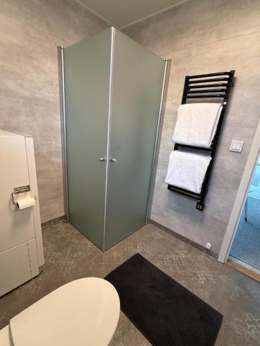 a bathroom with a toilet and a rack with towels at Villa Guldkusten in Kolsva