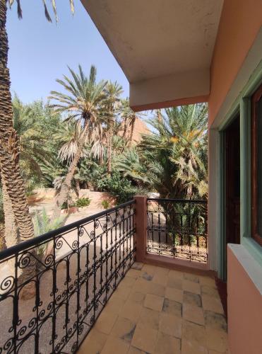 a balcony with palm trees and a view at Le LAC Auberge Camping Todra in Tinerhir