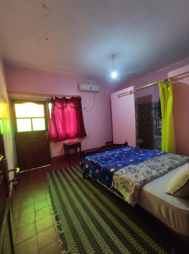 a bedroom with a bed and a window and a door at Le LAC Auberge Camping Todra in Tinerhir