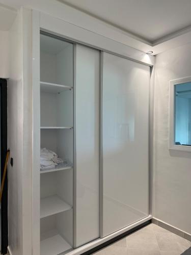 a white closet with glass doors in a room at Martil appartement avec vue sur mer in Martil
