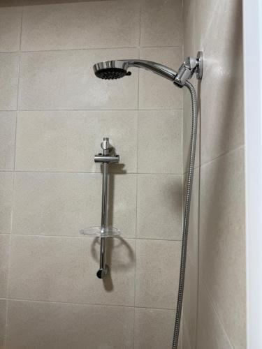 a shower with a shower head in a bathroom at Martil appartement avec vue sur mer in Martil