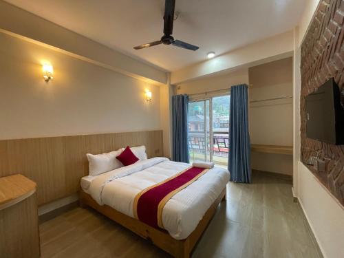 una stanza d'albergo con un letto e una finestra di Hotel Roadside Inn a Pokhara