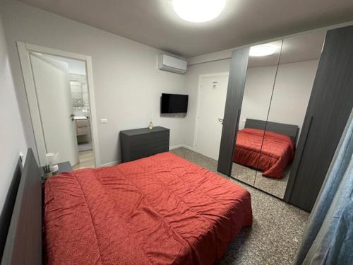 a bedroom with a red bed and a mirror at La casa di Amelie in Flero