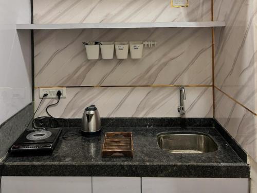 a kitchen counter with a sink and a stove at Aura Abode with private garden in Karjat