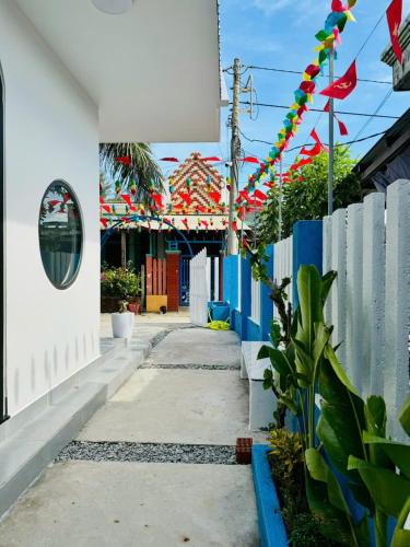 une rue avec des drapeaux colorés et une clôture dans l'établissement Nhan's Home, à Hưng Nhơn (2)