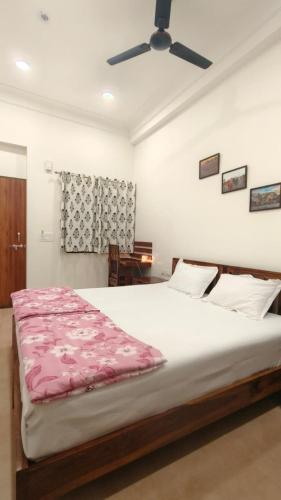 a bedroom with a large bed and a ceiling fan at Umaid Niwas Homestay in Jaipur