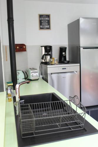 a kitchen with a dish drying rack in a sink at Ô Rethel Jacuzzi, Gîte Ardennes in Rethel
