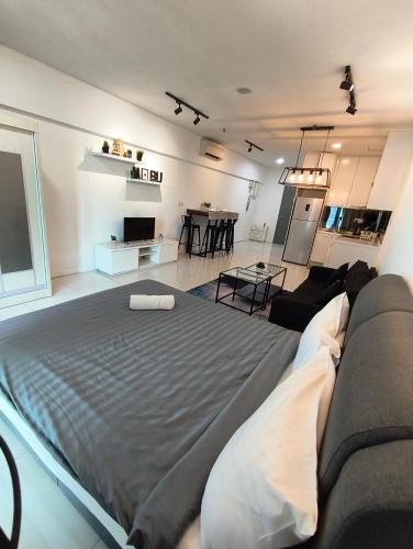 a living room with a large bed and a couch at Summer Suites KLCC by CozyNest in Kuala Lumpur