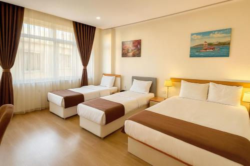 a hotel room with two beds and a window at VALENCE HOTEL Taksim in Istanbul