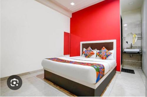 ein Schlafzimmer mit einer roten Wand und einem Bett mit Kissen in der Unterkunft Sunil palace in Parli Vaijnāth