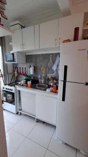 eine Küche mit weißen Schränken und einem weißen Kühlschrank in der Unterkunft Casa da Marcia in Belém