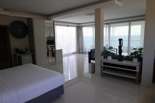 Un dormitorio con una cama y un televisor y ventanas. en Sunset Beach Hotel - Adults Only, en Haad Rin