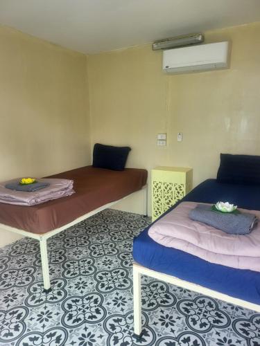 a room with two beds and a table at KiKi HOSTEL in Haad Rin