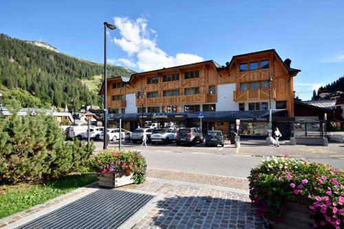 un grande edificio con auto parcheggiate in un parcheggio di BRENTA ALTA ALPINE LODGE MhD a Madonna di Campiglio