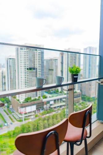 a balcony with two chairs and a view of a city at Ruby Luxurry Apartment - LUMIERE Riverside in Ho Chi Minh City