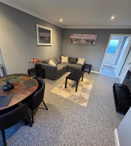 a living room with a couch and a table at 3 Bedroom FM Homes & Apartments Wishaw Motherwell in Dalziel