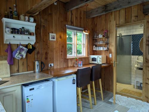 a kitchen with wooden walls and a counter with white appliances at Birkevang The Silo - Rural refuge in Faxe