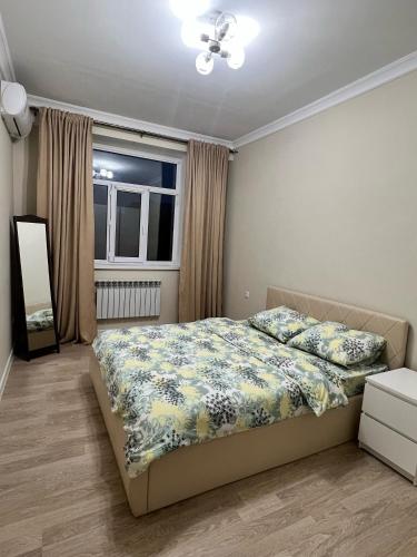 a bedroom with a bed and a window at ЖК Green Plaza Aktau Двухкомнатная большая in Aktau