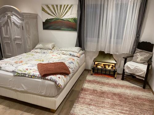 a bedroom with a bed and a chair and a fireplace at Smaragdherz in Bramberg am Wildkogel