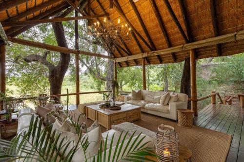 a screened in porch with a couch and a table at Karongwe - Kuname Safari Lodge in Hoedspruit