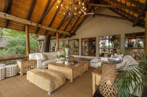 a living room filled with furniture and a chandelier at Karongwe - Kuname Safari Lodge in Hoedspruit