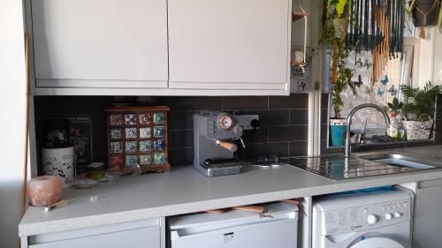 a kitchen with white cabinets and a counter top at Susies zen den by the sea in Swanage