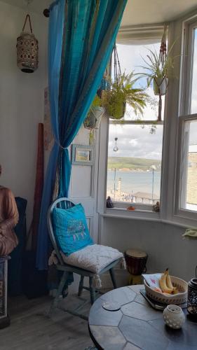 a room with a chair and a table and a window at Susies zen den by the sea in Swanage