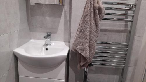a bathroom with a white sink and a towel at Susies zen den by the sea in Swanage
