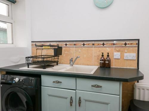 eine Küche mit Spüle und Waschmaschine in der Unterkunft Cosy Cottage in Cumbria, West of Lake District in Broughton Moor